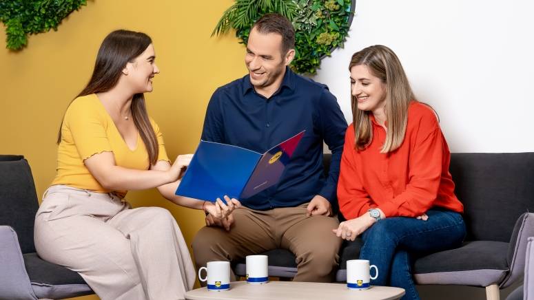 three people talking about a brochure