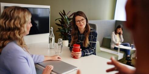 Women in meeting smiling