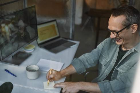 man in front of computer laughing